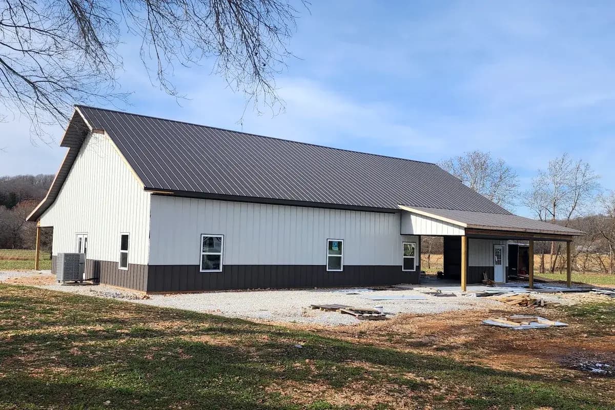 Barndominium with two-tone siding and covered lean-to