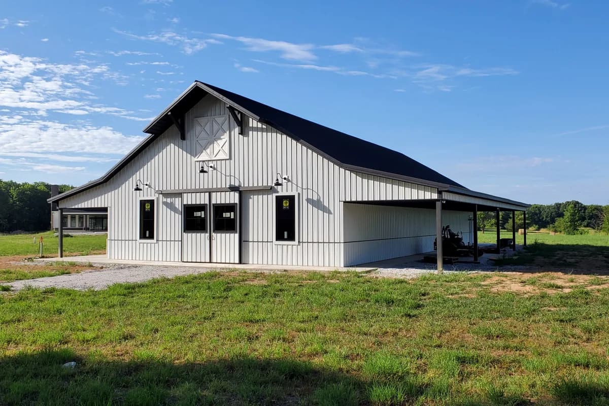 White shop building with lean-to equipment cover